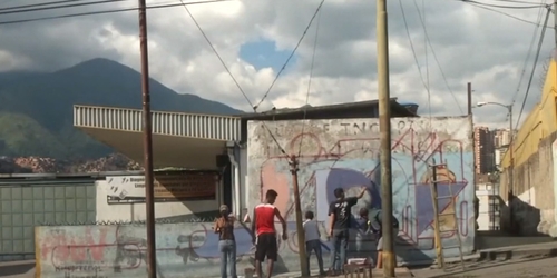 Венесуэльский художник рисует граффити поверх социалистической пропаганды